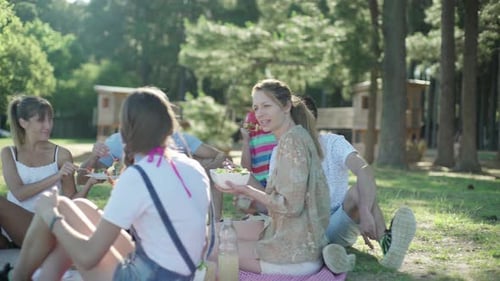 Family and Friends Enjoying Sunny Picnic in Woods