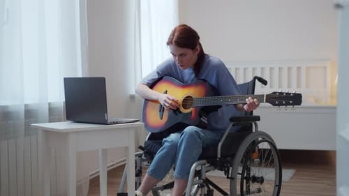 Woman in Wheelchair Plays Guitar With Laptop