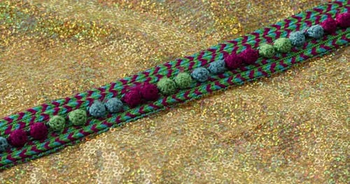 Motif de couleur tricoté sur tissu doré brillant avec gros plan à paillettes