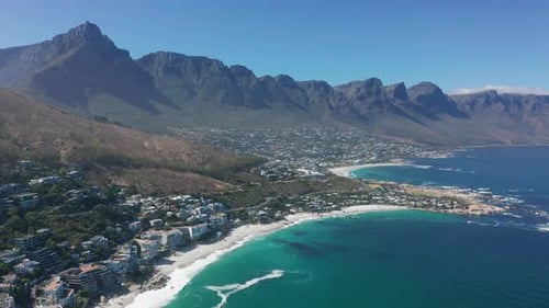 Aerial Moving Along the Shoreline of Camps Bay Cape Town South Africa with Twelve Apostles Mountains