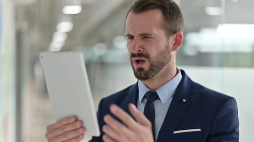 Man in Suit Frustrated with Tablet Indoors