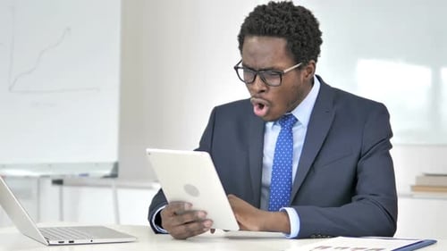 Shocked Businessman Looking at Tablet Device in Office