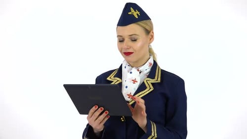 A Young Beautiful Stewardess Works on a Tablet with a Smile - White Screen Studio
