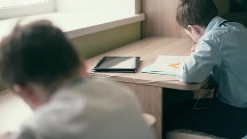 Children Studying in Classroom with Tablets and Notebooks