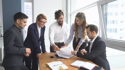 Managers View the Documents in the Office. Colleagues at Office Desk.