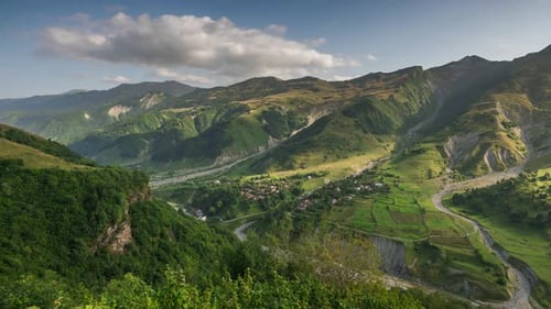 Alpine Landscape with Mountain Peaks, Green Meadows, Forest and Village in Valley Lights and Shadows