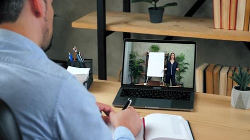 Man in Office Study Online Video Call Laptop Writes in Notebook Listen Teacher