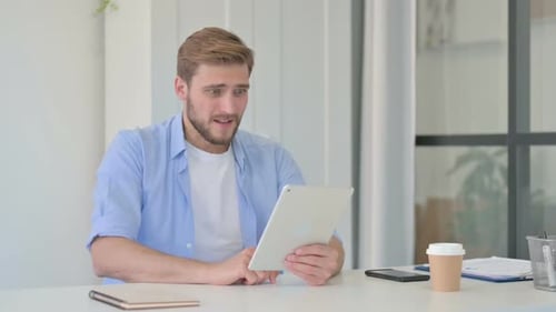 Man Upset by News on Tablet in Office