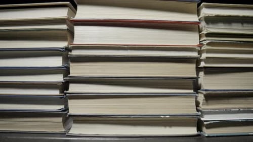 Stacks of Books are Lying on the Table in the Library
