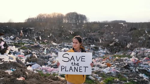 Woman Holding Save the Planet Sign at Landfill