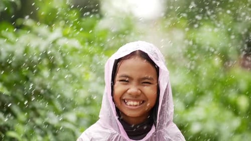 Happy Child Smiles in the Rain Outdoors