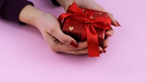Red Gift Held in Hands