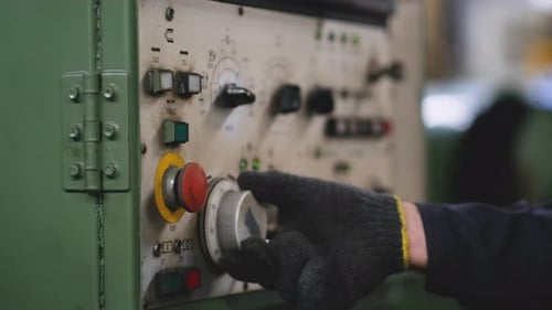 Close up technician hands adjust button and scale of the machine to operate it in the factory area