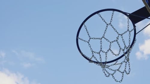 Basketball Ball Fall Through Basket with Net on Sunny Day