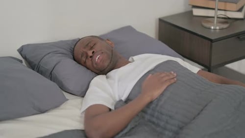 Homme africain se réveillant du cauchemar au lit