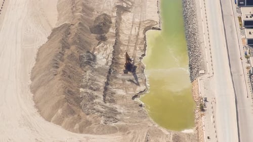 Baggermaschinen auf der Baustelle in der Wüste im Hintergrund