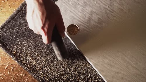 Caucasian Male Hand Vacuums Sawdust After Drilling From Floor and Carpet