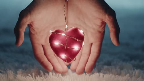 Glowing Heart Held Gently in Loving Hands