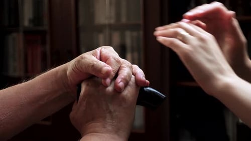 Senior's Hands Supported by Family Members