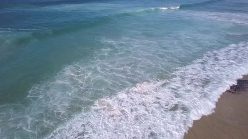 Aerial view of ocean waves crashing the shore