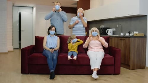 Family Puts on Protective Face Masks Together Indoors
