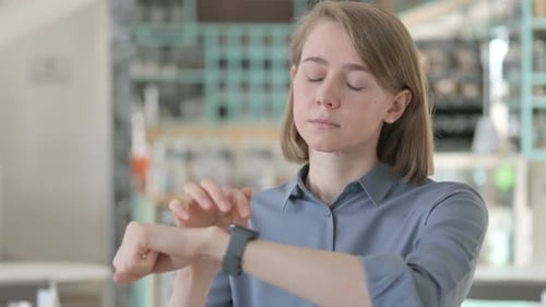 Woman Using a Smart Watch in Building