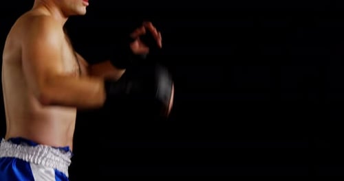 Boxer Kicks and Punches in Dark Studio