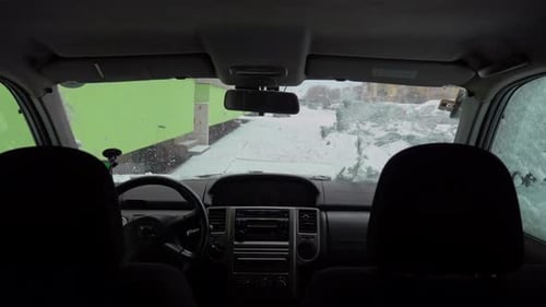 Clearing Snow From Car Windshield in Winter