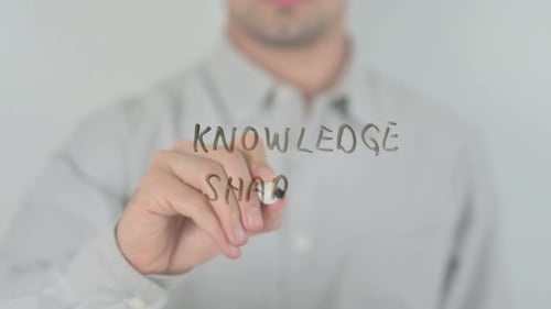 Man Writes 'Knowledge Sharing' on Clear Surface