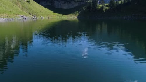 Aerial shot of blue mountain lake in the swiss alps, water relection, falensee, aplstein