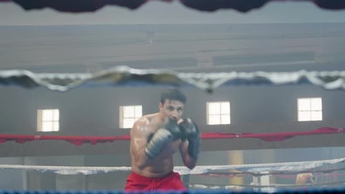 Young Male Boxer Doing Shadow Fight in Boxing Gym