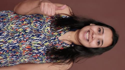 Smiling Brunette Woman Giving Thumbs Up
