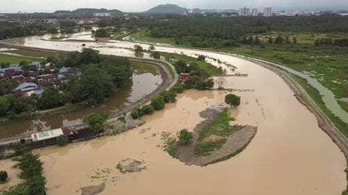 Flood at field beside river at kampung house