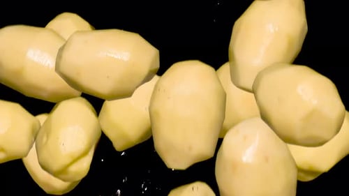 Peeled Potatoes with Water Droplets on Black Background