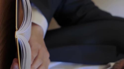 Man Fills Through Pages of Book Indoors