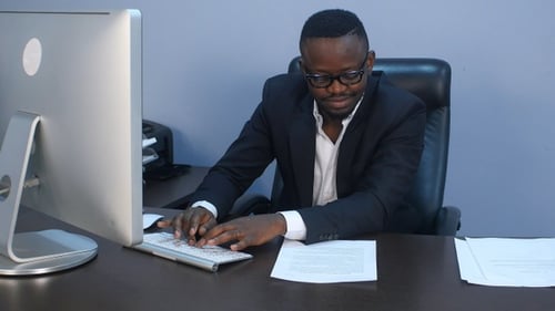 Man Typing at Desk in Modern Office