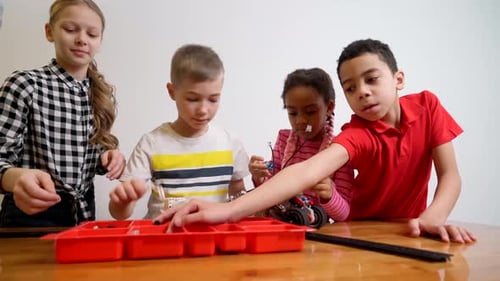 Kids Using Building Kit To Create Car.