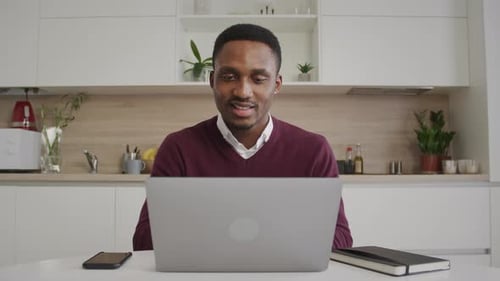African American Young Black Male Enterpreneur Working on His Laptop in His Bright Home Office Happy