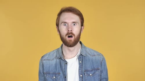 Man Reacts in Shock Against Yellow Backdrop