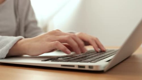 Woman Typing on Laptop Keyboard at Home