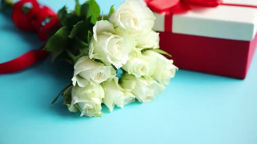 White Roses and Gift Box on Blue Surface