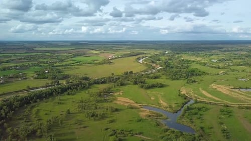 Flight Over Green Meadow and River in Spring