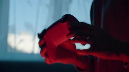 Hands Playing Video Game With Controller at Night