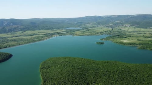 Aerial View on Water Reservoir at Mountain Valley Covered with Green Spring Forest