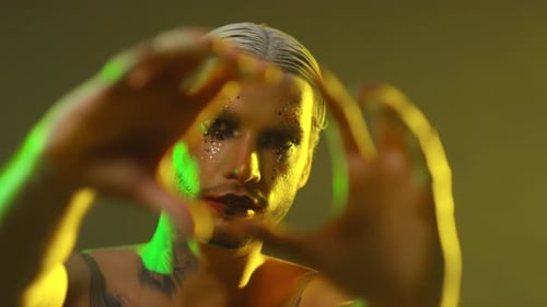 Portrait of Shirtless Man with Make-Up Posing for Camera