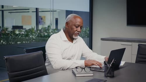Mature African American Businessman Working With Laptop In Office Typing On Keyboard
