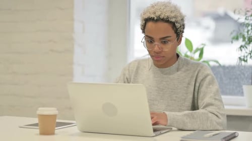 African Woman Working on Laptop in Office