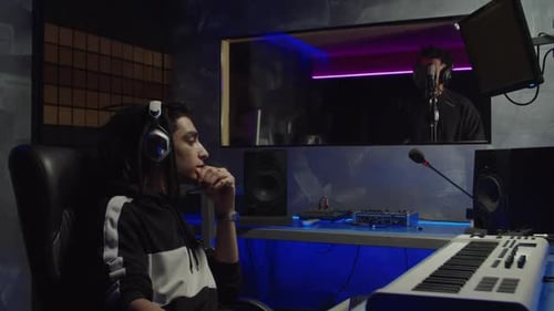 Trendy Sound Engineer Recording New Track of Hip Hop Artist in Modern Music Studio