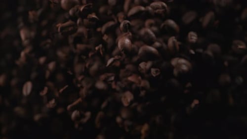 Kaffeebohnen fliegen, nachdem sie explodiert sind. Zeitlupe.