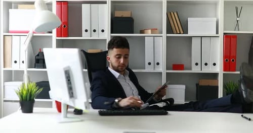 Geschäftsmann arbeitet mit Beinen auf dem Tisch im Büro
